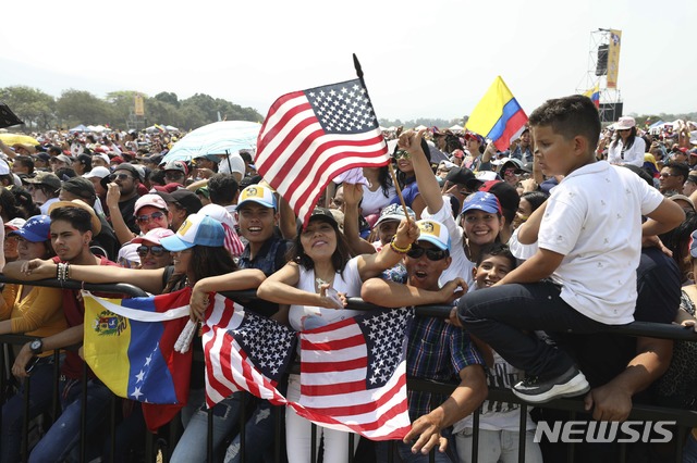 【쿠쿠타(콜롬비아)=AP/뉴시스】22일(현지시간) 콜롬비아 국경도시 쿠쿠타의 콜롬비아 측 티엔디타스 교량 근처에서 '베네수엘라 에이드 라이브' 콘서트가 열려 현장에 모인 군중이 미국과 베네수엘라 국기를 흔들고 있다.  한편 마두로 정부는 이날부터 이틀간 '베네수엘라에서 손을 떼라'는 주제로 콜롬비아와 베네수엘라를 연결하는 시몬 볼리바르 국제 다리에서 소위 맞불 음악회를 연다. 2019.02.23.
