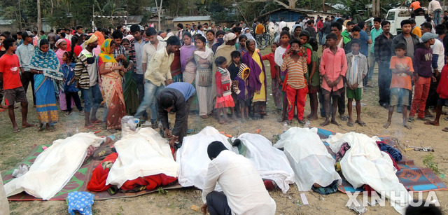 【고라가트=신화/뉴시스】22일(현지시간) 인도 아삼시 고라가트 지역에서 불법 밀주를 마시고 숨진 희생자들의 시신을 마을 사람들이 바라보고 있다. 밀주를 마신 사람들은 주로 차 농장 노동자들로 21일 밀주를 마신 후 의식을 잃었고 이 가운데 53명이 사망했다고 현지 관계자가 밝혔다. 2019.02.23. 