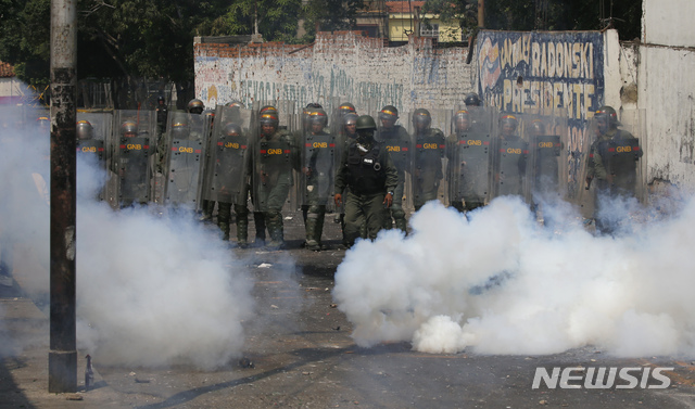 【우레나=AP/뉴시스】23일(현지시간)베네수엘라 우레나에서 시민과 군이 충돌한 가운데 군이 발사한 최루 가스가 피어오르고 있다. 이날 새벽 콜롬비아 접경지역인 베네수엘라 우레나에서는 구호 물품을 반입하려는 야당 인사들과 자원봉사자, 시민들이 이를 저지하는 군과 충돌했다. 베네수엘라 국경수비대는 우레나의 국경 다리에서 구호물자 수송을 위한 트럭의 통행을 위해 바리케이드를 치우려는 시민들에게 최루탄을 쏘아댔다.베네수엘라의 임시 대통령을 자임한 후안 과이도 국회의장은 이날을 인도주의 구호 물품 반입일로 선언한 바 있다. 2019.02.24.