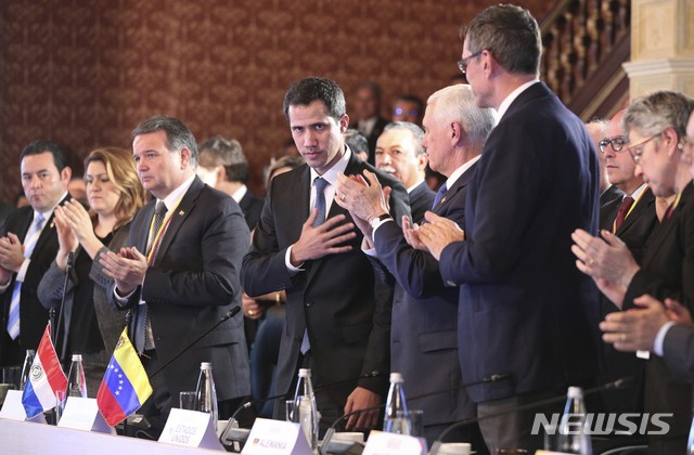 Flanked by Vice President Mike Pence, right center, Venezuela&#039;s self-proclaimed interim president Juan Guaido, acknowledges the applause during a meeting of the Lima Group concerning Venezuela at the Foreign Ministry in Bogota, Colombia, Monday, Feb. 25, 2019. (AP Photo/Martin Mejia)