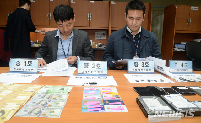 [전주=뉴시스] 김얼 기자= 불법 사이트 개설 운영자 검거 브리핑이 4일 전북 전주시 전북지방경찰청 브리핑룸에서 실시된 가운데 사이버수사대 소속 경찰관계자들이 압수한 증거품을 정리하고 있다. 2019.03.04. pmkeul@newsis.com 이 사진은 기사와 직접적인 관련 없음.