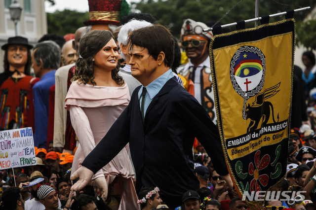 【올린다( 브라질) = AP/뉴시스】 브라질 카니발에서 야유의 대상이 된 자이르 보우소나루 대통령( 앞쪽)과 부인 미셸리 보우소나루의 거대한 인형.   
