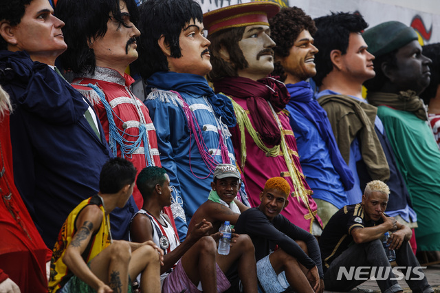【올린다( 브라질) = AP/뉴시스】 브라질도시 올린다의 카니발에서 사람들이 거대한 정치인들과 유명인사들의 인형을 준비해놓고 개막을 기다리고 있다.  맨 왼쪽부터 보우소나루 대통령, 비틀스의 인형들이 보인다.     