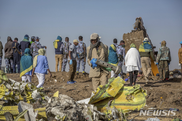 【아디스아바바=AP/뉴시스】지난 11일(현지시간) 에티오피아 수도 아디스아바바 남동쪽 60km가량 떨어진 비쇼프투 마을 항공기 추락 현장에서 관계자들이 사고기 잔해를 조사하고 있다. 에티오피아 항공 측은 탑승자 157명이 사망한 보잉 737 맥스 8기의 추락과 관련해 사전 예방 차원에서 모든 동종 항공기의 이륙을 금지했다고 대변인이 밝혔다. 2019.03.11.