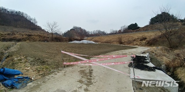 【보은=뉴시스】충북 보은군 삼승면의 한 야산 기슭 밭에 버려진 돼지 사체를 보은군이 비닐 포장 등으로 덮은 뒤 출입을 통제하고 있다.(사진=독자 제공) photo@newsis.com