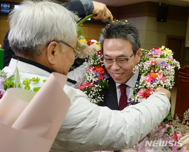 【전주=뉴시스】 김얼 기자= 제2회 전국동시조합장 선거 날인 13일 전북 전주시 전주농협 4층 회의실 개표소에서 전주농협 임인규 당선인이 지지자들에게 꽃다발을 선물받고 있다. 2019.03.13. pmkeul@newsis.com