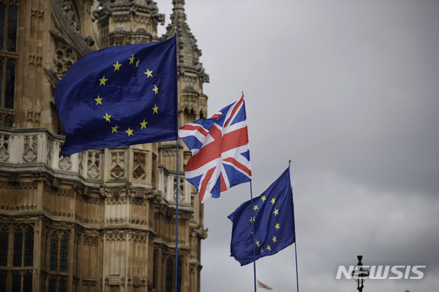 European flags and a British Union flag placed by anti-Brexit remain in the European Union supporters are blown by the wind across the street from the Houses of Parliament, not pictured, backdropped by Westminster Abbey in London, Monday, March 18, 2019. British Prime Minister Theresa May was making a last-minute push Monday to win support for her European Union divorce deal, warning opponents that failure to approve it would mean a long