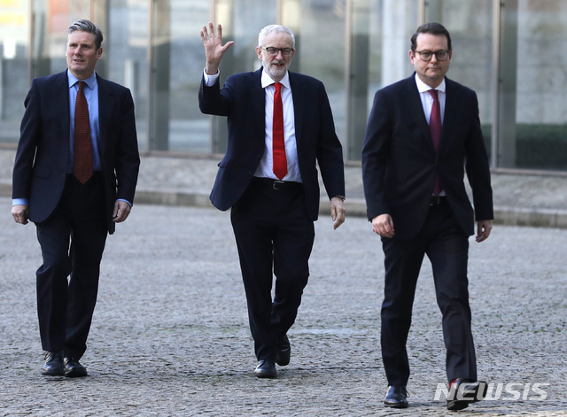 British Labour Party leader Jeremy Corbyn, center, waves as he arrives at EU headquarters prior to an EU summit in Brussels, Thursday, March 21, 2019. British Prime Minister Theresa May is trying to persuade European Union leaders to delay Brexit by up to three months, just eight days before Britain is scheduled to leave the bloc. (AP Photo/Frank Augstein)