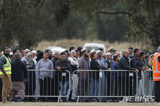 【크라이스트처치(뉴질랜드)=AP/뉴시스】지난주 크라이스트처치의 이슬람 사원 2곳에서 발생한 총기난사 사건으로 숨진 희생자들을 위한 뉴질랜드 최초의 이슬람 기도회에 참가하기 위해 뉴질랜드 전국에서 모인 추모객들이 22일 사건이 발생한 알누르 사원 건녀편의 기도회장 헤이글리 공원 앞에 줄지어 서 있다. 2019.3.22