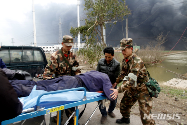 【옌청=AP/뉴시스】21일(현지시간) 중국 장쑤성 옌청 샹수이현 공단에 있는 공장에서 폭발 사고가 일어나 구조대가 부상자를 응급차에 태우고 있다.  이번 사고로 최소 47명이 숨졌고 중상자가 많아 인명피해는 더 늘어날 전망이다. 2019.03.22.