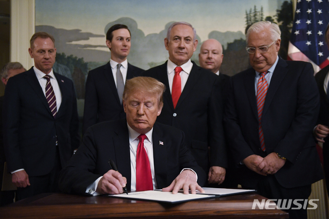 【워싱턴=AP/뉴시스】도널드 트럼프 미국 대통령이 25일(현지시간) 백악관을 방문한 베냐민 네타냐후 이스라엘 총리가 함께한 자리에서 골란 고원에 대한 이스라엘의 주권을 인정하는 포고문에 서명하고 있다.  트럼프 대통령은 포고문 서명을 마친 후 서명한 펜을 네타냐후 총리에게 건네면서 "이스라엘 국민에게 전해달라"고 말했다.네타냐후 총리는 "이스라엘은 트럼프 대통령보다 더 멋진 친구를 둔 적이 없다"며 트럼프 대통령의 서명을 반겼다. 2019.03.26.