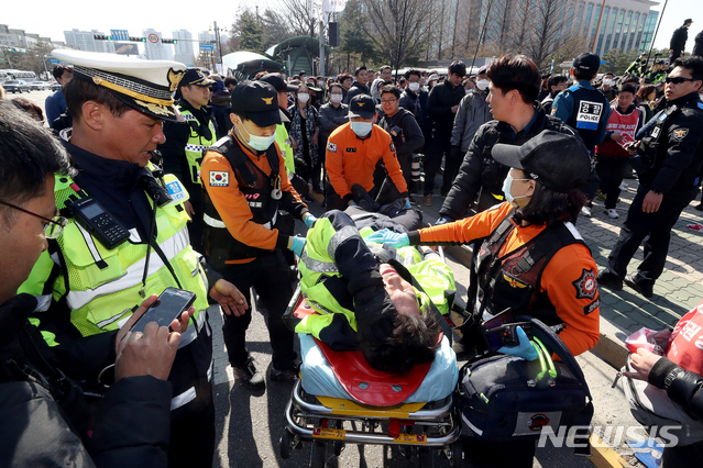 【서울=뉴시스】김병문 수습기자 = 3일 오후 서울 여의도 국회 정문에서 민주노총 주최로 열린 '노동법 개악 저지-노동기본권 쟁취 민주노총 결의대회'에서 다친 경찰이 실려나가고 있다. 2019.04.03. dadazon@newsis.com