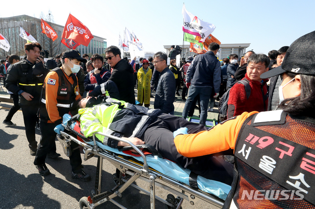 【서울=뉴시스】김병문 수습기자 = 지난 4월3일 오후 서울 여의도 국회 정문에서 민주노총 주최로 열린 '노동법 개악 저지-노동기본권 쟁취 민주노총 결의대회'에서 다친 경찰이 실려나가고 있다. 2019.04.03. dadazon@newsis.com