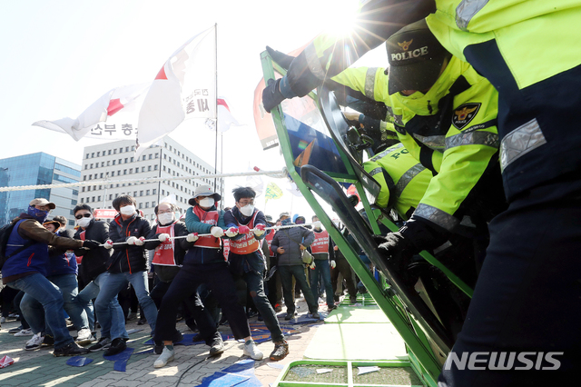 【서울=뉴시스】김병문 수습기자 = 민주노총 조합원들이 지난 3일 오후 서울 여의도 국회 정문에서 열린 '노동법 개악 저지-노동기본권 쟁취 민주노총 결의대회'에서 국회 진입하기 위해 바리케이드를 허물고 있다. 2019.04.03. dadazon@newsis.com