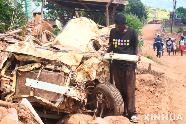 【 치마니마니( 짐바브웨)= 신화/뉴시스】지난달 사이클론 이다이로 초토화된 짐바브웨 마을에서 홍수로 부서진 차량의 쓸만한 부속품을 찾고 있는 주민.  
