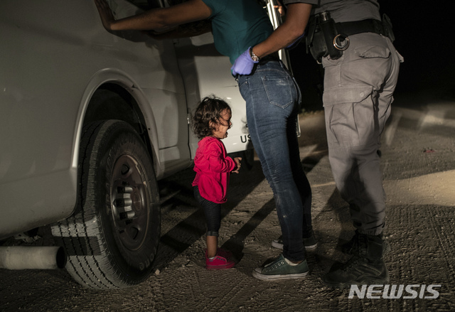 【암스테르담( 네델란드) = AP/뉴시스】올해의 세계보도사진 상 수상작 "국경에서 울고 있는 소녀"  ( 게티 이미지스 소속의 존 무어 촬영). 이 사진은 지난 해 6월 텍사스주 매캘런의 국경수비대가 아이 엄마를 체포해 수색하는 장면이다.   