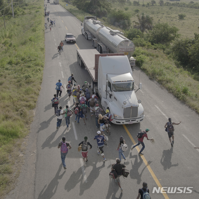 【AP/뉴시스】네델란드 세계 보도사진 재단이 11일(현지시간) 발표한 올해의 보도사진 수상작 "이주자들의 캐러밴". 지난 해 10월 30일 멕시코의 파타나페텍 교외의 도로를 걷던 이민들이 이들을 태워주기 위한 대형버스를 향해 달려가는 모습을 담은 피에터 텐 호펜의 사진작품이다.  