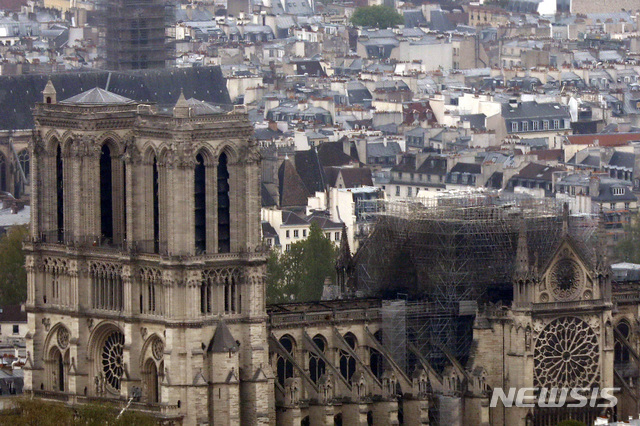 Notre Dame cathedral is pictured from the top of the Montparnasse tower, Tuesday April 16, 2019 in Paris. Firefighters declared success Tuesday morning in an over 12-hour battle to extinguish an inferno engulfing Paris&#039; iconic Notre Dame cathedral that claimed its spire and roof, but spared its bell towers. (AP Photo/Thibault Camus)
