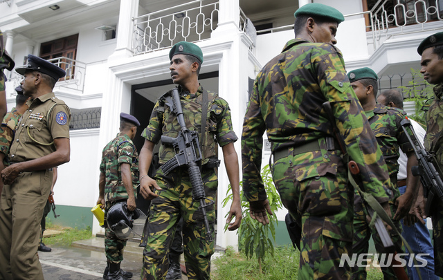 스리랑카 특공대원들이 21일 동시다발 폭발물 공격 용의자들의 은신처로 의심되는 건물 앞에 서 있다    AP
