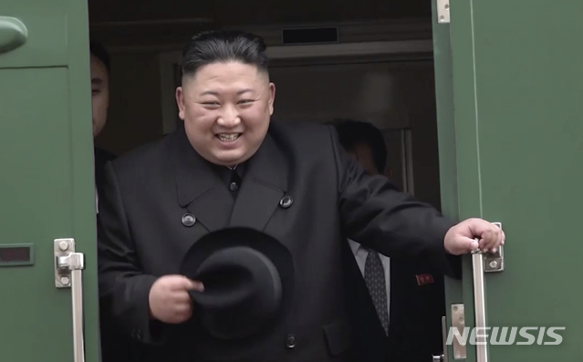 【하산=AP/뉴시스】김정은 북한 국무위원장이 24일 러시아 연해주 남단 하산스키 하산역에서 블라디보스토크로 출발하는 특별열차에 탑승해 자신을 영접했던 인사들에게 웃음을 보이고 있다. 2019.04.24.