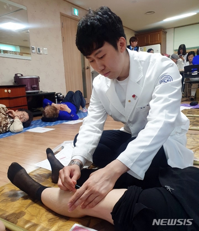 【서울=뉴시스】강남자생한방병원 의료진이 경로당을 방문한 환자에게 침을 놓고 있다. (사진= 자생한방병원 제공)