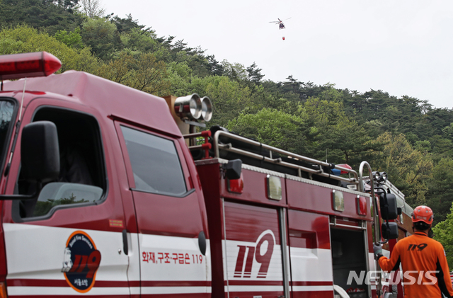 【서울=뉴시스】김병문 수습기자 = 29일 오후 서울 성북구 북한산 일대에서 도심산불에 특화된 산불진화 장비 활용 훈련이 진행되고 있다. 소방재난본부는 이 날 도심산불 대비 유관기관 합동 산불진화 훈련에서 소방항공대 헬기투입 공중방수와 소방호스와 이동식 엔진(가반식)펌프를 직결한 고압방수 훈련을 실시했다. 2019.04.29. photo@newsis.com