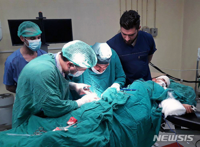 시리아 관영 통신 사나 제공 사진으로, 12일 하마주 한 병원에서 북쪽 이들립주 반군 로켓 부상자가 수술받고 있다  AP 