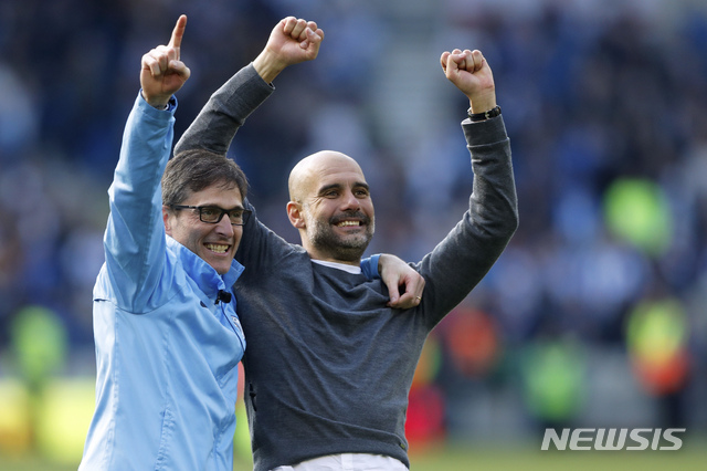 Manchester City coach Pep Guardiola, right, celebrates at the end of the English Premier League soccer match between Brighton and Manchester City at the AMEX Stadium in Brighton, England, Sunday, May 12, 2019. Manchester City defeated Brighton 4-1 to win the championship. (AP Photo/Frank Augstein)