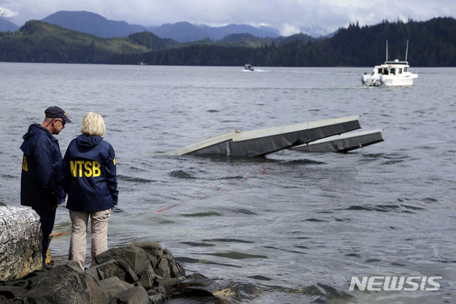 【케치칸( 미 알래스카주)= AP/뉴시스】알래스카에서충돌사고를 낸 뒤 추락한 수상 플로트기에 대해 15일 사고현장 조사에 나선 연방교통안전위원회(NTSB)의 조사원들.  이 곳에서는 13일 착륙지점에서 두 대의 수상기가 충돌해 6명이 죽고 10명이 다쳤다.    
