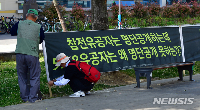 【광주=뉴시스】류형근 기자 = 5·18민주화운동 발상지인 광주 북구 전남대학교 후문 앞에서 17일 오전 자유연대·턴라이트 등 보수 성향의 단체가 '5·18유공자 명단 공개 ' 등의 내용이 적힌 현수막을 걸고있다. 2019.05.17 hgryu77@newsis.com