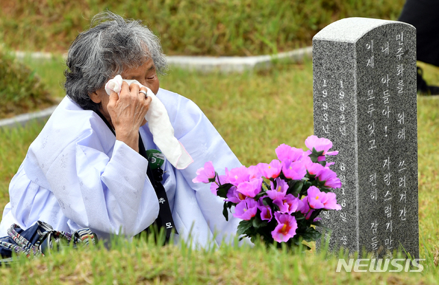 【광주=뉴시스】류형근 기자 = '오월 광주, 정의로운 대한민국'을 주제로 제39주기 5·18민주화운동 기념식이 18일 오전 광주 북구 운정동 국립5·18민주묘지에서 열린 가운데 한 열사의 어머니가 묘지 앞에서 오열을 하고있다. 2019.05.18 hgryu77@newsis.com
