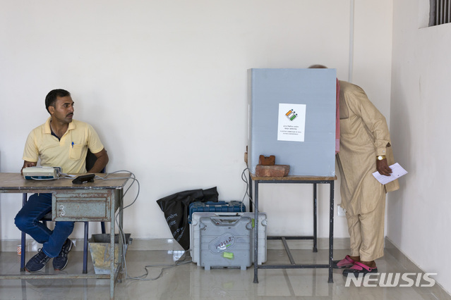 A polling official, left waits for confirmation of successful polling as an Indian man votes in the seventh and final phase of national elections in Dharmsala, India, Sunday, May 19, 2019. Sunday&#039;s polling wraps up a 6-week-long long, grueling campaign season with Prime Minister Narendra Modi&#039;s Hindu nationalist party seeking reelection for another five years. Counting of votes is scheduled for May 23. (AP Photo/Ashwini Bhatia)