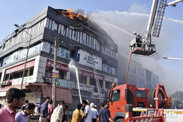 【수라트(인도)=AP/뉴시스】24일(현지시간) 인도 서부 구자라트주 수라트시에 있는 한 건물에서 화재가 발생해 20명이 사망했다. 사망자 대부분은 이 건물에서 수업을 받고 있던 10대 청소년들인 것으로 알려졌다. 2019.05.25