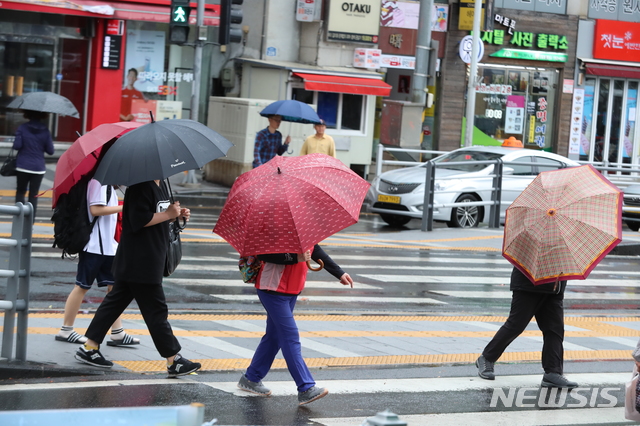 【제주=뉴시스】우장호 기자 = 제주시청 인근 횡단보도에 시민들이 우산을 쓰고 걸어가고 있다. (사진=뉴시스DB) woo1223@newsis.com 