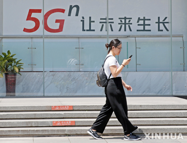 【베이징=신화/뉴시스】중국 공업정보화부는 6일 차이나모바일, 차이나텔레콤, 차이나유니콤, 차이나브로드캐스팅네트워크 4곳에 5G 영업 허가증을 발급했다. 지난 3일 베이징 도심에서 한 여성이 '미래 성장을 해 5G 발전'이라는 문구가 적힌 광고문 앞을 지나고 있다. 2019.06.07 