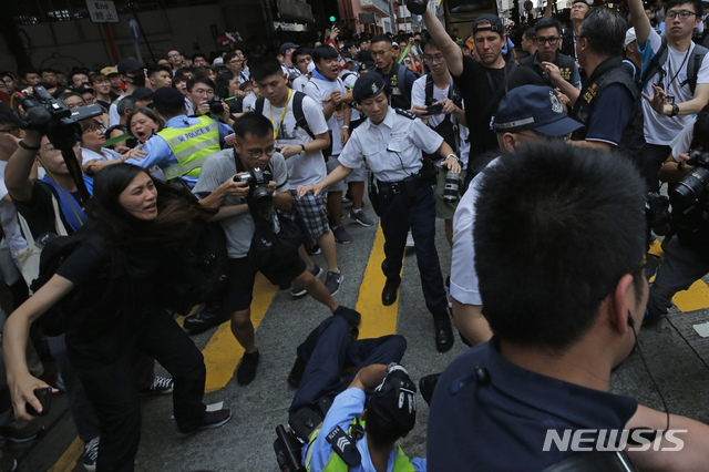 【홍콩=AP/뉴시스】홍콩에서 9일 한 경찰이 시민들과 대치하던 중 쓰러져 있다. 이날 홍콩에서는 범죄인 인도법에 반대하는 대규모 시위가 벌어졌다. 2019.06.10