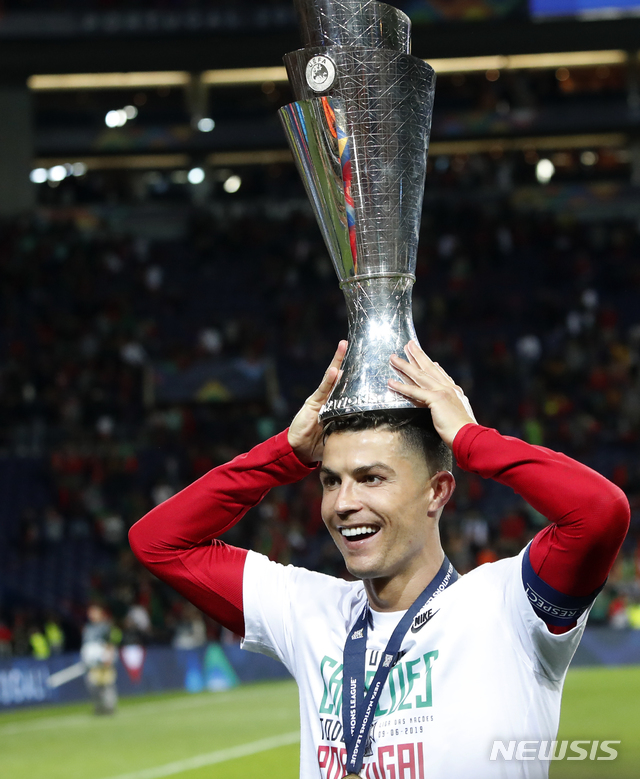 【포르투(포르투갈)=AP/뉴시스】크리스티아누 호날두가 9일(현지시간) 포르투갈 포르투의 에스타디우 두 드라강에서 열린 2018-19 UEFA 네이션스 리그에서 네덜란드를 꺾고 우승, 트로피를 머리에 올리고 포즈를 취하고 있다.  포르투갈은 네덜란드를 1-0으로 물리치고 우승해 지난 유럽선수권(유로 2016) 우승에 이어 메이저대회 역대 두 번째 우승 트로피를 차지했다. 호날두는 국가대표 유니폼을 입고 개인 통산 두 번째 우승 트로피를 들어 올렸다. 2019.06.10.