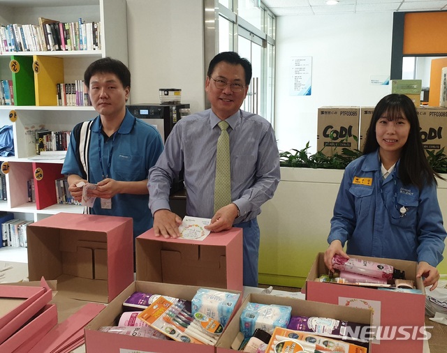 【서울=뉴시스】12일 포스코ICT 손건재 사장(가운데)이 광양사무소에서 임직원들과 함께 지역 청소년들에게 전달할 '핑크박스'를 포장하고 있다. (사진=포스코ICT 제공)