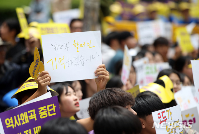 [서울=뉴시스]박미소 기자 = 12일 오후 서울 종로구 구 주한일본대사관 앞에서 열린 1391차 일본군 성노예제 문제 해결을 위한 정기 수요시위에서 학생들이 구 일본대사관을 향해 손피켓을 들고 있다. 2019.06.12. misocamera@newsis.com