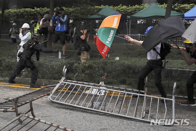 【홍콩=AP/뉴시스】홍콩 입법원 근처에서 12일 범죄인 인도법 반대 시위 참가자들이 우산으로 경찰이 쏜 최루액(페퍼 스프레이)를 막고 있다. 2019.06.12 