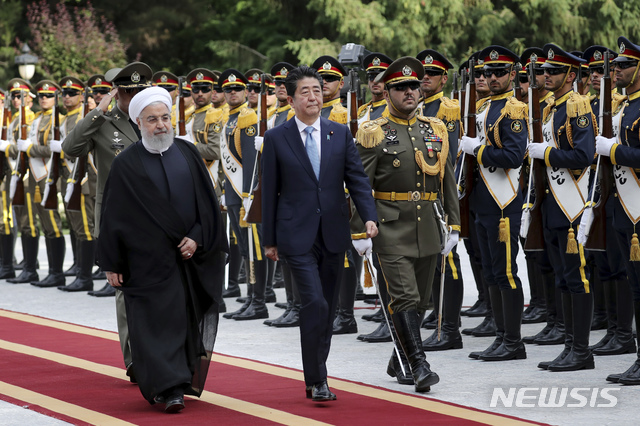 【테헤란(이란)=AP/뉴시스】이란을 방문한 아베 신조(安倍晉三) 일본 총리(가운데)가 12일 테헤란의 사다바드 왕궁에서 하산 로하니 이란 대통령의 환영을 받으며 이란 의장대를 사열하고 있다. 아베 총리는 미-이란 간 긴장을 완화시킬 방안에 대해 로하니 대통령과 솔직하게 논의했다고 말하고 더 많은 인내를 촉구했다. 2019.6.13