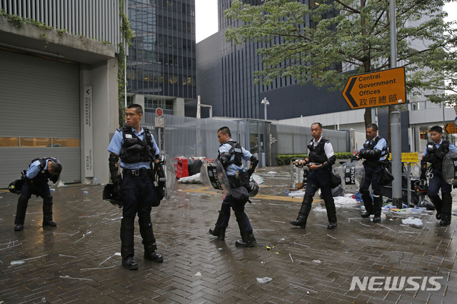 【홍콩=AP/뉴시스】'범죄인 인도법 개정안'에 반발해 거리로 뛰쳐나온 시위대가 13일 오전 0시 무렵 해산을 시작하면서 홍콩 도심 교통이 대부분 복구됐다. 사진은 시위 잔재가 남아 있는 입법회 청사를 경찰이 순찰하고 있는 모습. 2019.06.13
