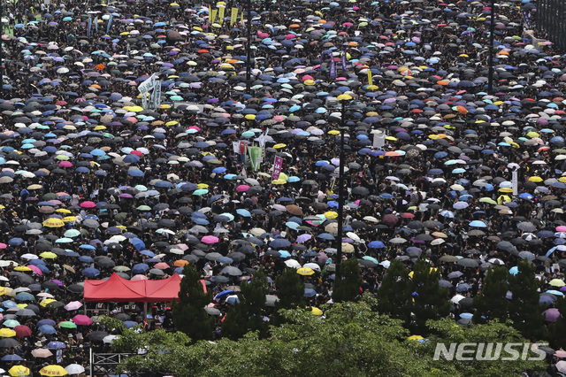  【홍콩=AP/뉴시스】검은 옷을 차려 입은 수많은 홍콩 시민들이 16일 비가 내리는데도 불구하고 우산을 쓴 채 캐리 람 행정장관의 사퇴와 범죄인 인도법의 연기 대신 완전한 철회를 요구하는 '검은 대행진'을 펼치고 있다. 2019.6.16 