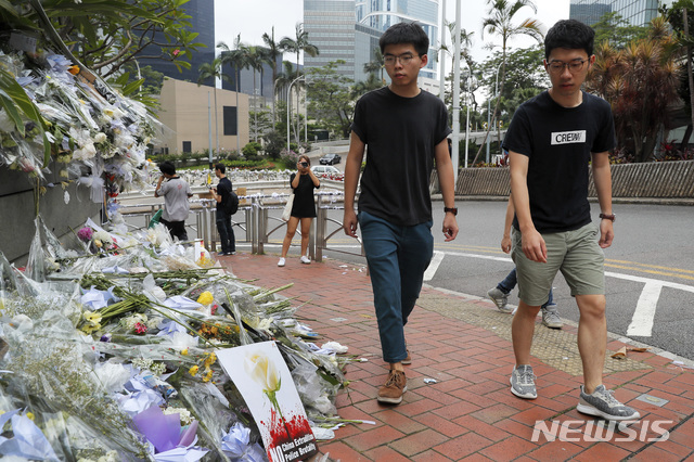 【홍콩=AP/뉴시스】홍콩 우산시위를 주도했던 조슈아 웡(사진 왼쪽)이 17일 라이치콕(荔枝角) 구치소에서 출소한 뒤 범죄인 인도법 반대 시위 중 사망한 시위자를 추모소를 찾고 있다. 2019.06.17