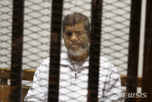 【카이로=AP/뉴시스】이집트의 첫 민선 대통령이었던 무함마드 무르시 전 대통령이 17일(현지시간) 67세를 일기로 사망했다.지난 2014년 5월 8일 카이로 법정에 출석한 무르시 전 대통령의 모습. 2019.06.18 