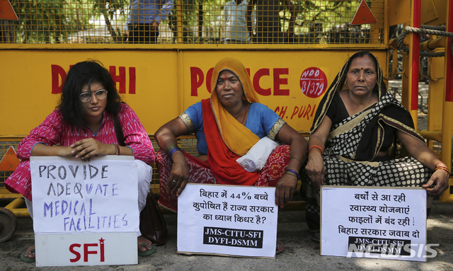 【뉴델리(인도)=AP/뉴시스】지난 6월18일(현지시간) 인도 수도 뉴델리의 한 경찰서 바리케이드 그늘에서 인도 좌익 여성 운동가들이 최근 뇌 질환으로 100여 명의 어린이가 숨진 것에 대해 적절한 치료 등을 요구하며 시위를 벌이고 있다. 2019.10.18