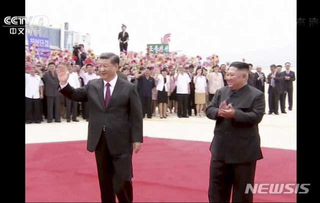 [평양=CCTV·AP/뉴시스] 시진핑 중국 국가주석(왼쪽)이 2019년 6월20일 북한 평양 순안공항에 도착해 영접나온 김정은 국무위원장과 함께 환영객들을 향해 박수치고 있다. 사진은 중국 CCTV 영상을 캡처한 것이다. 2024.06.19.