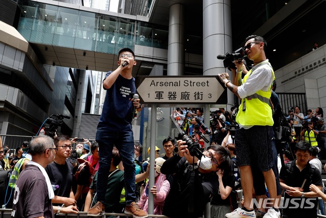 【홍콩=AP/뉴시스】 지난 2014년 홍콩 우산시위를 주도했던 조슈아 웡이 21일 범죄인 인도법 반대 시위대에게 경찰본부를 에워싸줄 것을 요청하고 있다. 2019.06.21