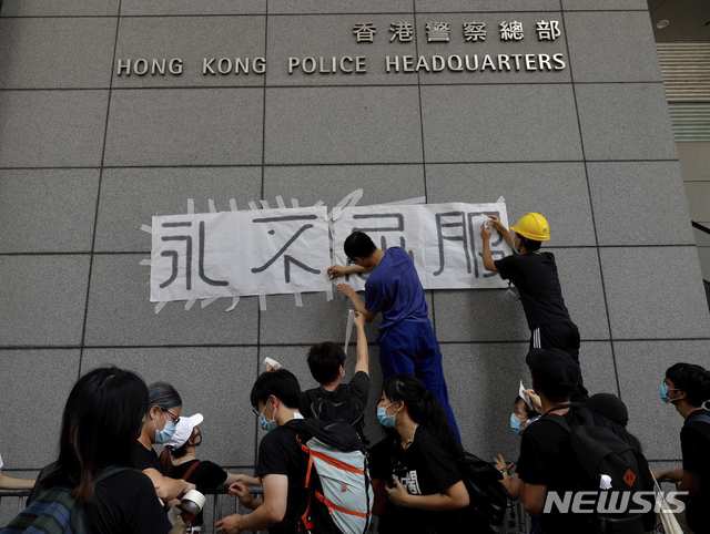 【홍콩=AP/뉴시스】 홍콩 시위대가 21일 홍콩 경찰본부 벽에 "절대 지지 않는다"는 글씨를 붙여놓고 있다. 사우스차이나모닝포스트(SCMP)는 시민 1000여명이 '법죄인 인도 법안'의 완전한 철회를 요구하며 21일 다시 시위에 나섰다고 보도했다. 2019.06.21.