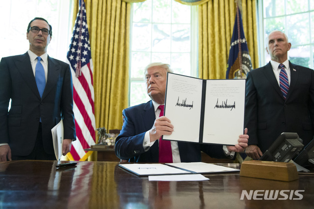 【워싱턴=AP/뉴시스】도널드 트럼프 미국 대통령이 24일(현지시간) 백악관 집무실에서 이란 최고지도자 등을 겨냥한 추가제재 행정명령에 서명한 뒤 이를 들어 보이고 있다. 2019.06.25.